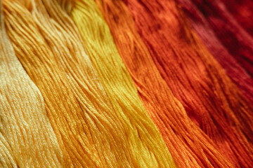 Floss threads in warm colors, gradient transition.