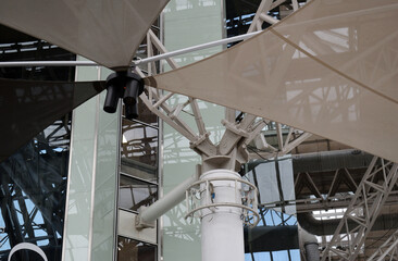 Interior View of Sun Shades Suspended from  Glass and Steel Roof of Modern Industrial Building 