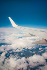 Obraz premium Airplane wing flying above clouds