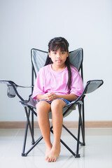 Girl sitting on camping chair table, isolated white background.