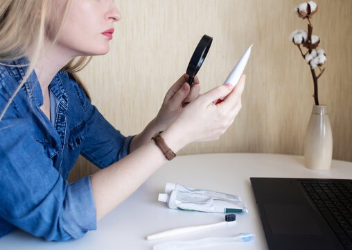 Toothpaste ingredients. Girl at laptop checks composition of toothpaste and is surprised by dangerous composition of product. Emulsifiers, preservatives, dyes, PEG, SLS, parabens, diethanolamine