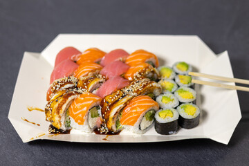 Tasty Colorful assorted Set of different type Sushi with chopsticks. Dinner in Japanese style. Healthy food. Filadelfia and Maki sushi rolls with Avocado, Tuna, Salmon, fish and Prawns.