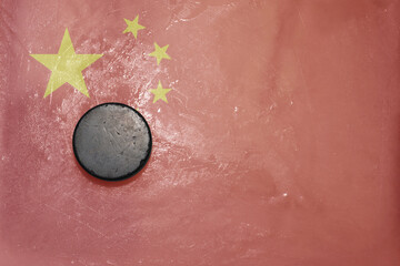 old hockey puck is on the ice with national flag of china .