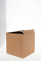 Brown square corrugated cardboard box on a white background. Added shadows, copy space