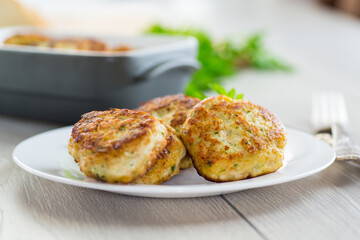 fried meat cutlets in a ceramic form on a wooden table
