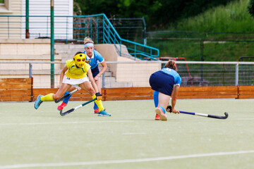 Female field hockey player performing a penalty shot towards the net