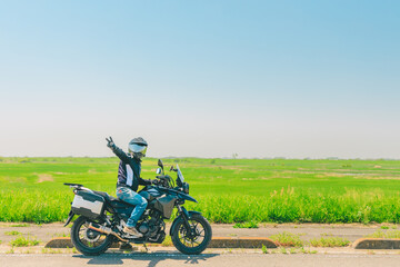 Obraz na płótnie Canvas 草原の中を走るバイク