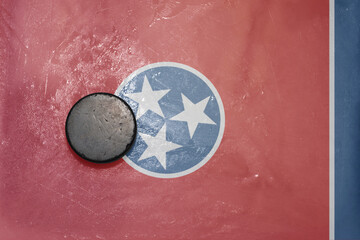 old hockey puck is on the ice with national flag of tennessee state.