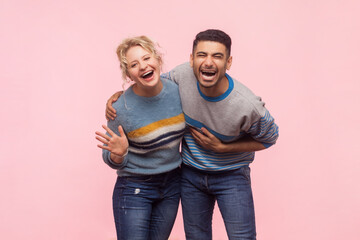 Portrait of extremely happy woman and man standing together laughing out loud hearing funny joke...
