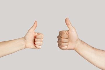 Closeup of diverse man and woman hands showing thumb up, like gesture, approved sign. Indoor studio...