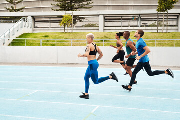Group, people and running in stadium for workout or sport on track, training or exercise for wellness. Team, athlete and arena with runner for freedom or health, commitment and strong with cardio
