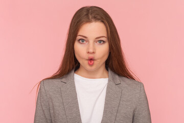 Portrait of childish playful woman with brown hair making fish lips, looking at camera, having fun,...