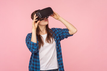 Portrait of concentrated brown haired woman in vr headset, playing virtual reality game, innovative...