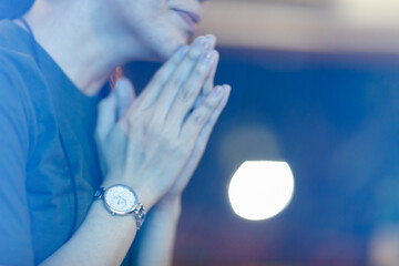 Blur focus praying and worshiping GOD in Church. Hand praying, palms up, Concept Praise, and worship with faith, spirituality, and Surrender.