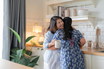 good old friend visit home asian mature woman friend talking standing in kitchen positive conversation good relation friendship reunion home visit casual relax hand hold coffee cup goodvibe at home