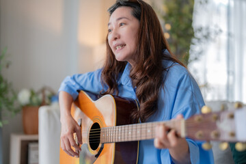 asian adult woman friend gathering having fun together while singing and playing the guitar at...