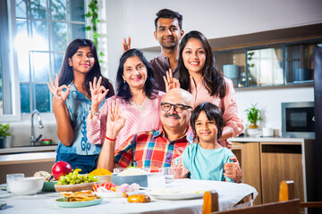 Happy Indian asian family having lunch at home and posing for photo