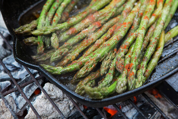 Grilled asparagus. Pile of buttered asparagus spears roasting on an outdoor grill.