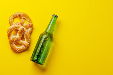 Beer bottle and pretzels on yellow background