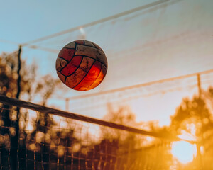 An intense close-up of a volleyball mid-air during a game, capturing the dynamic nature of the sport