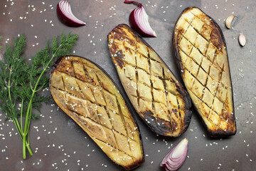 Baked eggplant with onions, garlic and sesame seeds. Sprig of dill