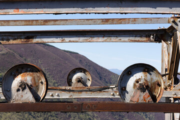 Detailed closeup of metal wheel with cable abandoned equipment for mining.
