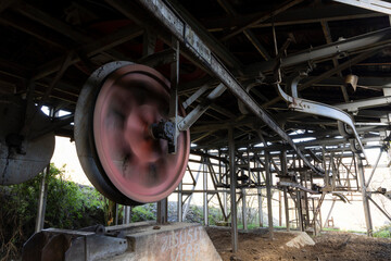 Closeup of rusty metal wheel from industrial mining equipment in abandoned factory.
