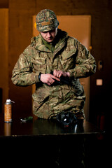 In a professional shooting range military man in ammunition reloads a pistol