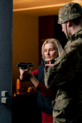 close up in a professional shooting range military man tells and shows a girl the correct stance...