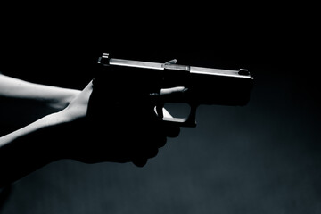 close-up of female hands holding pistol contrast light readiness to shoot correct position of hands