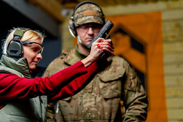 At a professional shooting range a military man controls the technique of shooting a pistol the...