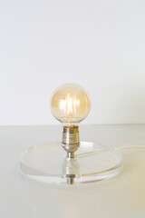 Post-modern light with a clear base and a bare Edison bulb.