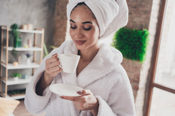 Photo portrait of attractive young woman hold cup drink tea head wrapped towel dressed bath robe home interior enjoy weekend
