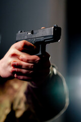 close up at a professional shooting range military trainer holds a pistol pointing down