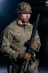 Fototapeta premium In professional shooting range, a military man in ammunition tells how to use a NATO rifle