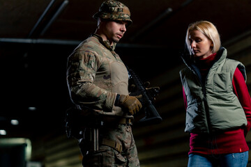 At a professional shooting range military trainer tells a girl how to properly handle NATO weapons