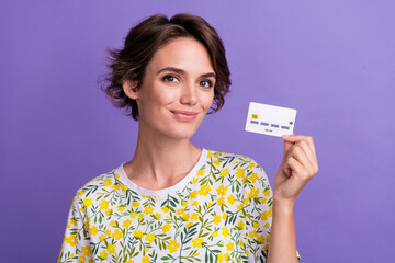 Photo of pretty young woman hold debit card wear t-shirt isolated on violet color background