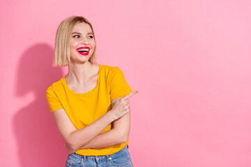 Photo of shiny dreamy lady dressed yellow t-shirt pointing finger looking empty space isolated pink...