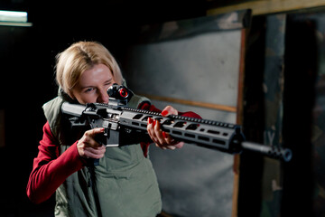 At a professional shooting range girl takes aim before firing from a NATO rifle