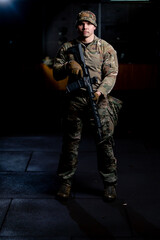 a professional shooting range military tactics instructor stands with a NATO rifle