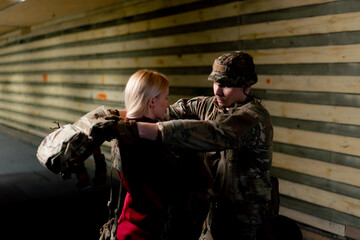 At a professional shooting range military trainer puts tactical ammunition on a cheap girl