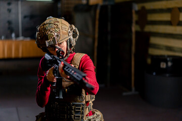 In a professional shooting range young girl in tactical ammunition is preparing to shoot