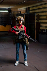 at a professional shooting range girl in tactical ammunition stands with a NATO rifle