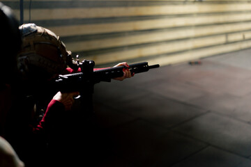 At a professional shooting range cheap girl in tactical ammunition fires a shot