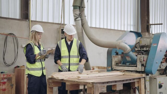 Two Carpenter uses large industrial machinery. For polishing wood faces and cut the wood into pieces for storage and export