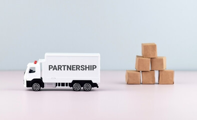 White toy truck on blocks with the text PARTNERSHIP.