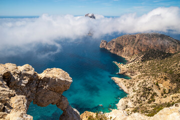 Mystical view of Es Vedra island covered with clouds from the Eye of Es Vedra viewpoint, Sant Josep de Sa Talaia, Ibiza, Balearic Islands, Spain
