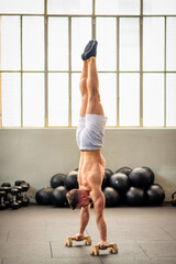 Strong man doing handstand in gym