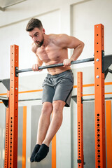 Athletic man doing muscle up exercise on bar
