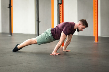 Strong man doing plank exercise on floor